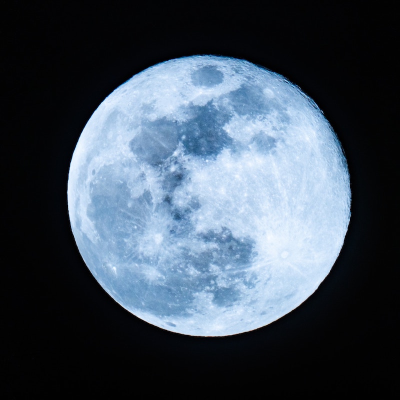 Bright full moon with visible craters against a black night sky.